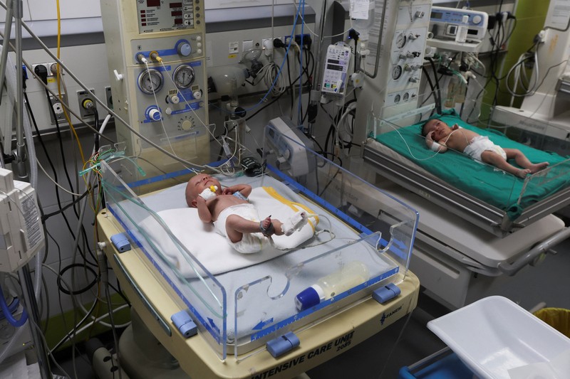 Palestinians pray near the body of baby Saeed Abdeen, who according to the medics died due to cold weather, in Khan Younis, southern Gaza Strip, December 18, 2025. REUTERS/Ramadan Abed