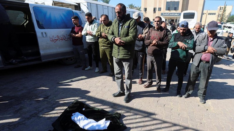 Palestinians pray near the body of baby Saeed Abdeen, who according to the medics died due to cold weather, in Khan Younis, southern Gaza Strip, December 18, 2025. REUTERS/Ramadan Abed