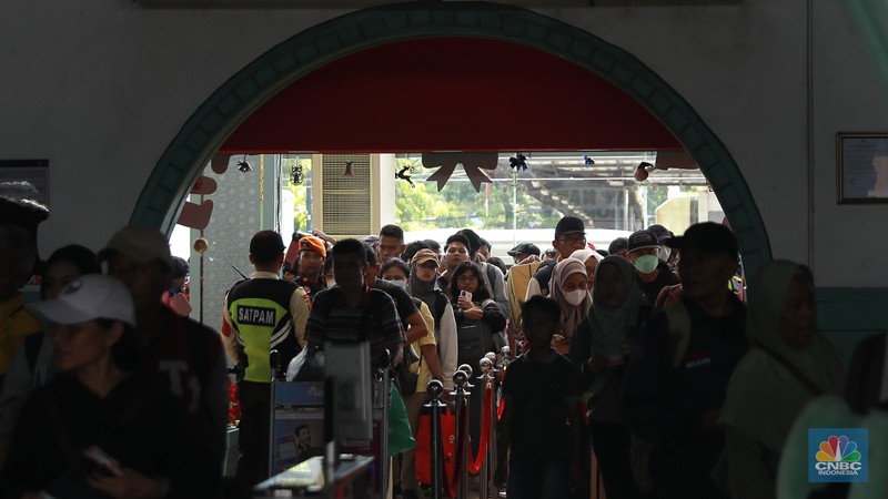 Calon penumpang menunggu keberangkatan kereta api di Stasiun Pasar Senen, Jakarta, Selasa (23/12/2025). (CNBC Indonesia/Muhammad Sabki)