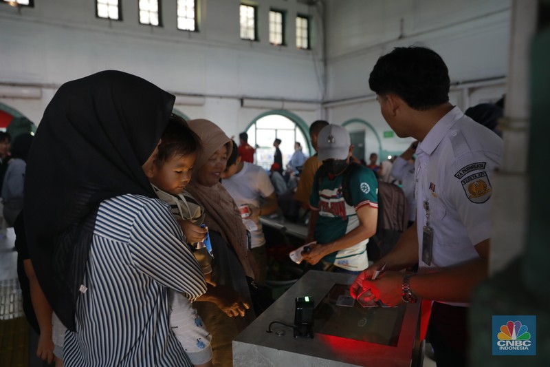 Calon penumpang menunggu keberangkatan kereta api di Stasiun Pasar Senen, Jakarta, Selasa (23/12/2025). (CNBC Indonesia/Muhammad Sabki)