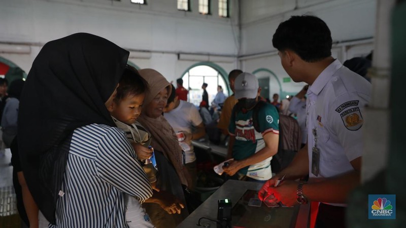 Calon penumpang menunggu keberangkatan kereta api di Stasiun Pasar Senen, Jakarta, Selasa (23/12/2025). (CNBC Indonesia/Muhammad Sabki)