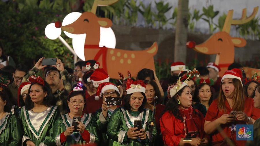 Paduan suara menyanyikan lagu Natal Christmas Carol Colossal Vol 2 di jalur pedestrian depan FX Sudirman, Jakarta,  Selasa (23/12/2025) malam. (CNBC Indonesia/Muhammad Sabki)