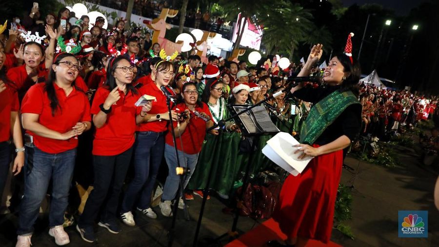 Paduan suara menyanyikan lagu Natal Christmas Carol Colossal Vol 2 di jalur pedestrian depan FX Sudirman, Jakarta,  Selasa (23/12/2025) malam. (CNBC Indonesia/Muhammad Sabki)