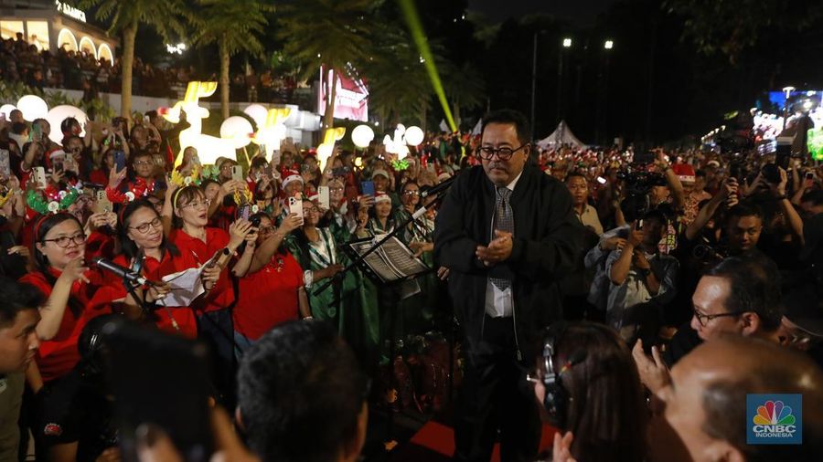 Paduan suara menyanyikan lagu Natal Christmas Carol Colossal Vol 2 di jalur pedestrian depan FX Sudirman, Jakarta,  Selasa (23/12/2025) malam. (CNBC Indonesia/Muhammad Sabki)