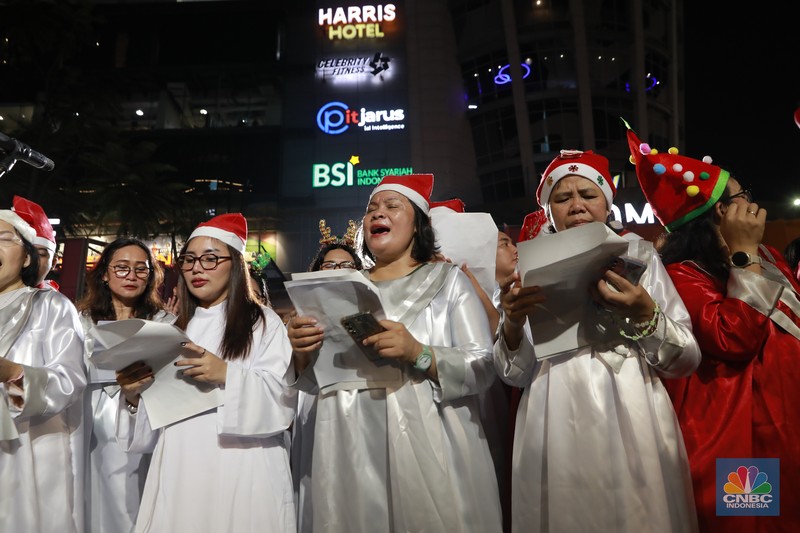 Paduan suara menyanyikan lagu Natal Christmas Carol Colossal Vol 2 di jalur pedestrian depan FX Sudirman, Jakarta,  Selasa (23/12/2025) malam. (CNBC Indonesia/Muhammad Sabki)