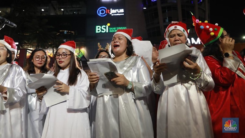 Paduan suara menyanyikan lagu Natal Christmas Carol Colossal Vol 2 di jalur pedestrian depan FX Sudirman, Jakarta,  Selasa (23/12/2025) malam. (CNBC Indonesia/Muhammad Sabki)