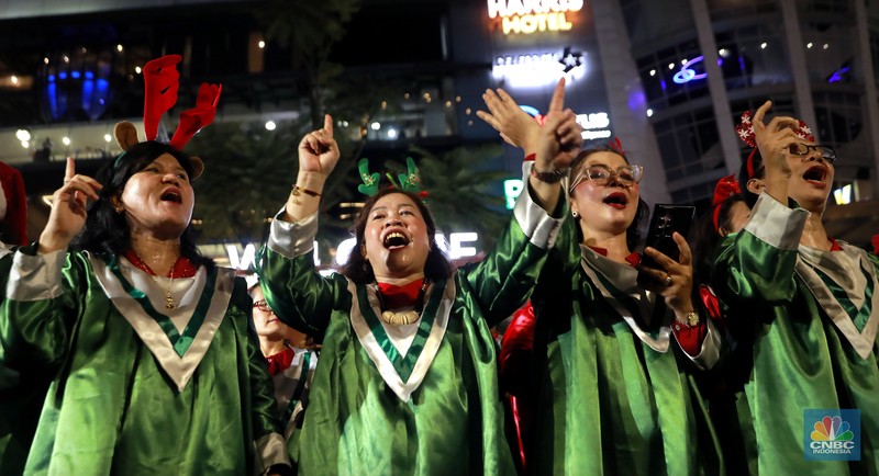 Paduan suara menyanyikan lagu Natal Christmas Carol Colossal Vol 2 di jalur pedestrian depan FX Sudirman, Jakarta,  Selasa (23/12/2025) malam. (CNBC Indonesia/Muhammad Sabki)