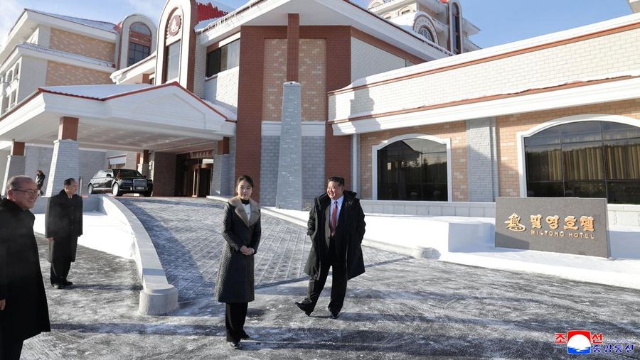 Pemimpin Korea Utara Kim Jong Un dan putrinya Kim Ju Ae berdiri di luar Hotel Milyong saat menghadiri upacara peresmian hotel-hotel di resor wisata di Kota Samjiyon, Korea Utara, 20 Desember 2025, dalam foto yang dirilis oleh Kantor Berita Pusat Korea (KCNA) resmi Korea Utara. (KCNA via REUTERS)