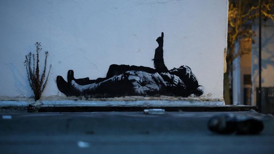 Seseorang berjalan melewati mural baru yang dilaporkan karya seniman anonim Banksy, di Tottenham Court Road, London, Inggris, 22 Desember 2025. (REUTERS/Isabel Infantes)