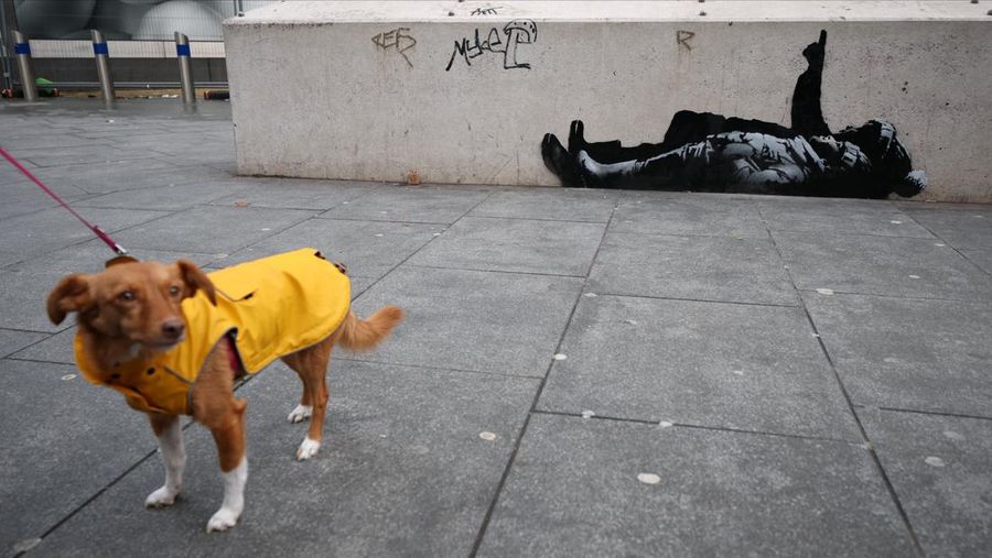 Seseorang berjalan melewati mural baru yang dilaporkan karya seniman anonim Banksy, di Tottenham Court Road, London, Inggris, 22 Desember 2025. (REUTERS/Isabel Infantes)