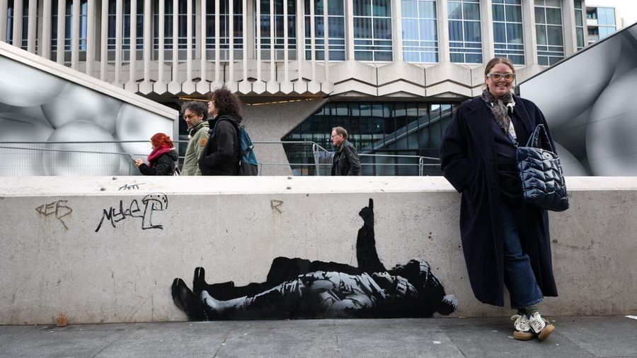 Seseorang berjalan melewati mural baru yang dilaporkan karya seniman anonim Banksy, di Tottenham Court Road, London, Inggris, 22 Desember 2025. (REUTERS/Isabel Infantes)