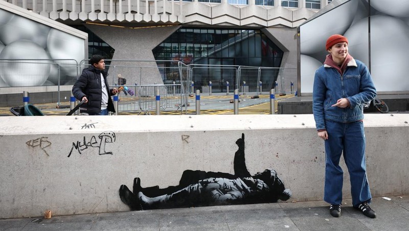 Seseorang berjalan melewati mural baru yang dilaporkan karya seniman anonim Banksy, di Tottenham Court Road, London, Inggris, 22 Desember 2025. (REUTERS/Isabel Infantes)