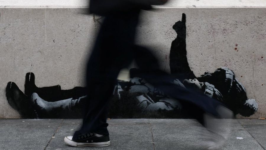 Seseorang berjalan melewati mural baru yang dilaporkan karya seniman anonim Banksy, di Tottenham Court Road, London, Inggris, 22 Desember 2025. (REUTERS/Isabel Infantes)