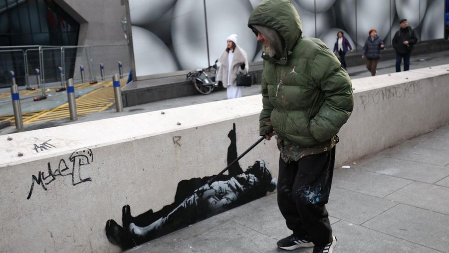 Seseorang berjalan melewati mural baru yang dilaporkan karya seniman anonim Banksy, di Tottenham Court Road, London, Inggris, 22 Desember 2025. (REUTERS/Isabel Infantes)
