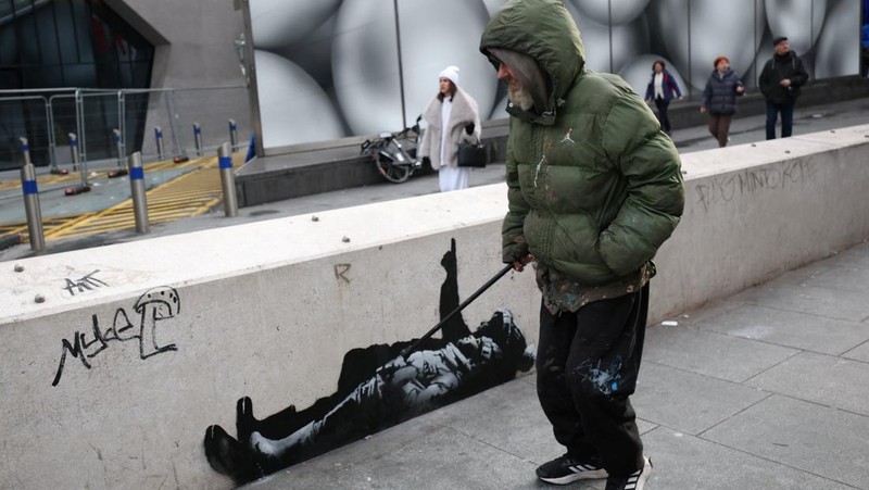Seseorang berjalan melewati mural baru yang dilaporkan karya seniman anonim Banksy, di Tottenham Court Road, London, Inggris, 22 Desember 2025. (REUTERS/Isabel Infantes)