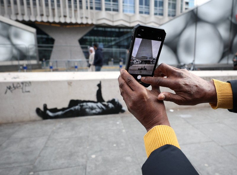 Seseorang berjalan melewati mural baru yang dilaporkan karya seniman anonim Banksy, di Tottenham Court Road, London, Inggris, 22 Desember 2025. (REUTERS/Isabel Infantes)
