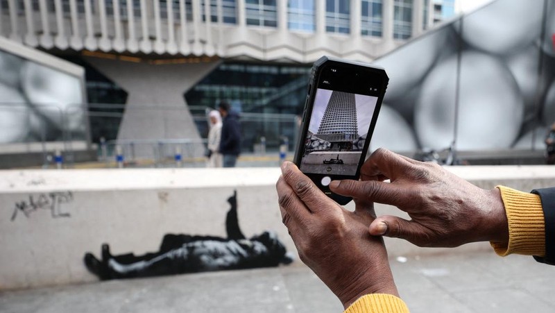 Seseorang berjalan melewati mural baru yang dilaporkan karya seniman anonim Banksy, di Tottenham Court Road, London, Inggris, 22 Desember 2025. (REUTERS/Isabel Infantes)