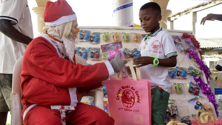 A man dressed as Santa Claus distributes gifts during his gift-giving tour in the floating village of Ganvie ahead of the holiday celebrations in Cotonou, Benin, December 23, 2025. REUTERS/Charles Placide Tossou