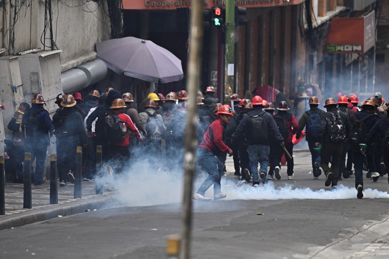 Para penambang yang berafiliasi dengan serikat pekerja utama Bolivia bentrok dengan petugas polisi selama protes menyusul keputusan pemerintah Bolivia untuk mencabut subsidi bahan bakar, yang telah menyebabkan kenaikan harga solar dan bensin, di La Paz, Bolivia, 23 Desember 2025. (REUTERS/Claudia Morales)