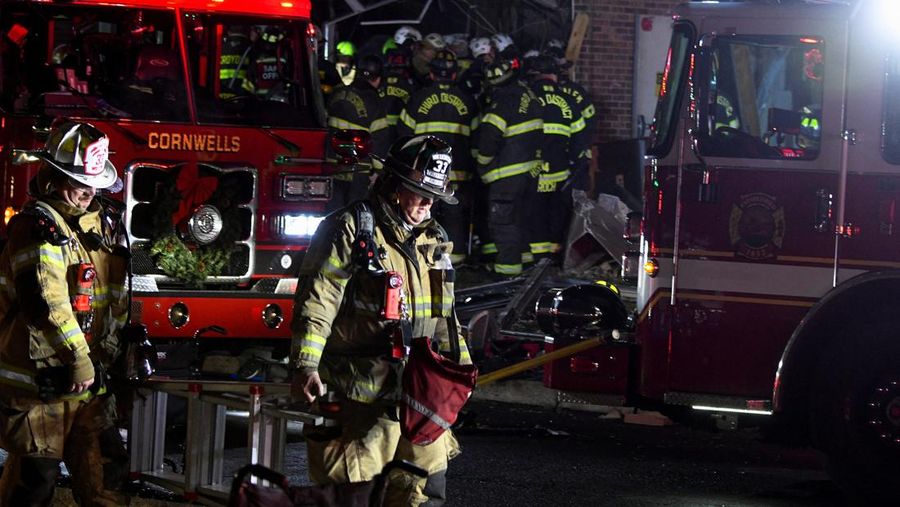 Seorang petugas polisi menjaga agar jalan tetap aman bagi petugas pertolongan pertama setelah ledakan gas dan kebakaran yang diduga menyebabkan kerusakan besar pada panti jompo Silver Lake Healthcare Center di Bristol, Pennsylvania, AS, 23 Desember 2025, dalam gambar diam dari video. (Lacey Latch/USA Today Network via REUTERS)