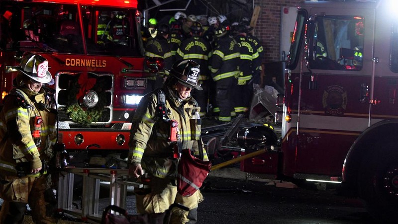 Seorang petugas polisi menjaga agar jalan tetap aman bagi petugas pertolongan pertama setelah ledakan gas dan kebakaran yang diduga menyebabkan kerusakan besar pada panti jompo Silver Lake Healthcare Center di Bristol, Pennsylvania, AS, 23 Desember 2025, dalam gambar diam dari video. (Lacey Latch/USA Today Network via REUTERS)