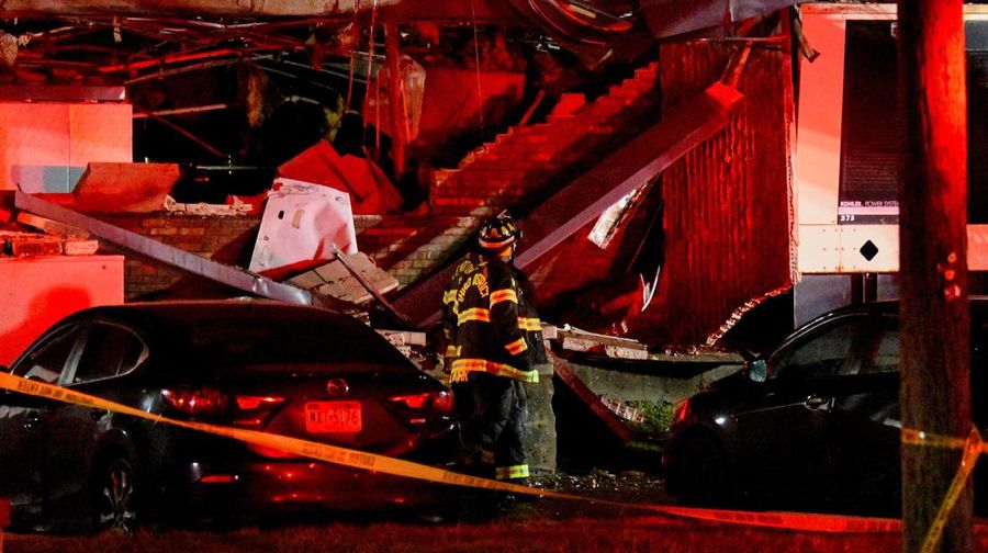 Seorang petugas polisi menjaga agar jalan tetap aman bagi petugas pertolongan pertama setelah ledakan gas dan kebakaran yang diduga menyebabkan kerusakan besar pada panti jompo Silver Lake Healthcare Center di Bristol, Pennsylvania, AS, 23 Desember 2025, dalam gambar diam dari video. (Lacey Latch/USA Today Network via REUTERS)