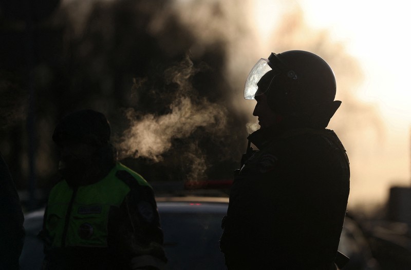 Petugas penegak hukum memblokir jalan di dekat lokasi kejadian di mana dua petugas polisi lalu lintas dan satu orang lainnya tewas dalam ledakan di Moskow, Rusia, 24 Desember 2025. REUTERS/Ramil Sitdikov