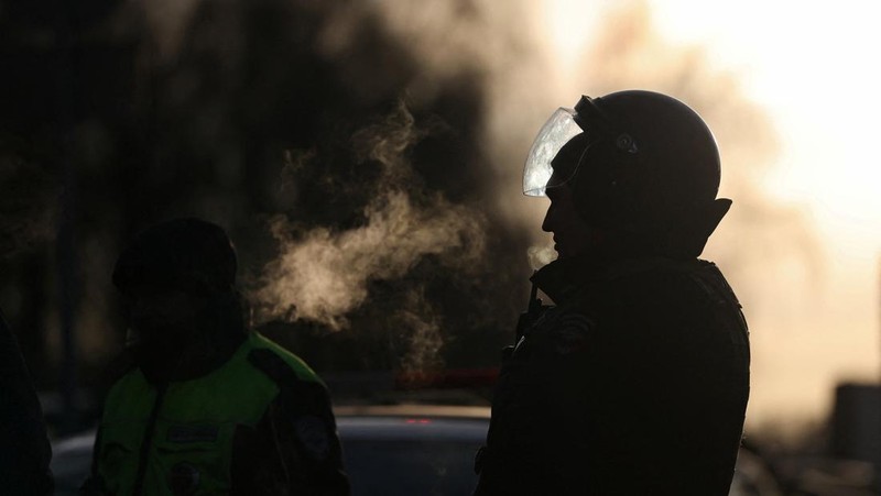 Petugas penegak hukum memblokir jalan di dekat lokasi kejadian di mana dua petugas polisi lalu lintas dan satu orang lainnya tewas dalam ledakan di Moskow, Rusia, 24 Desember 2025. REUTERS/Ramil Sitdikov