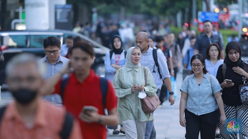 Sejumlah pekerja melintas saat jam pulang kerja di Kawasan Pedestrian Sudirman, Jakarta, Rabu (24/12/2025).  (CNBC Indonesia/Muhammad Sabki)