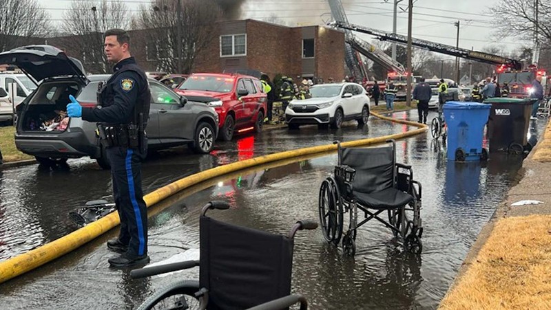 Seorang petugas polisi menjaga agar jalan tetap aman bagi petugas pertolongan pertama setelah ledakan gas dan kebakaran yang diduga menyebabkan kerusakan besar pada panti jompo Silver Lake Healthcare Center di Bristol, Pennsylvania, AS, 23 Desember 2025, dalam gambar diam dari video. (Lacey Latch/USA Today Network via REUTERS)