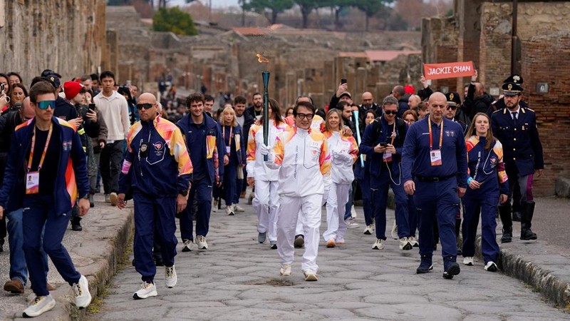 Olympics - 2026 Milano-Cortina Winter Olympics - 2026 Milano-Cortina Winter Olympics Torch Relay - Pompeii, Italy - December 22, 2025 Torchbearer actor Jackie Chan reacts during the torch relay REUTERS/Matteo Ciambelli