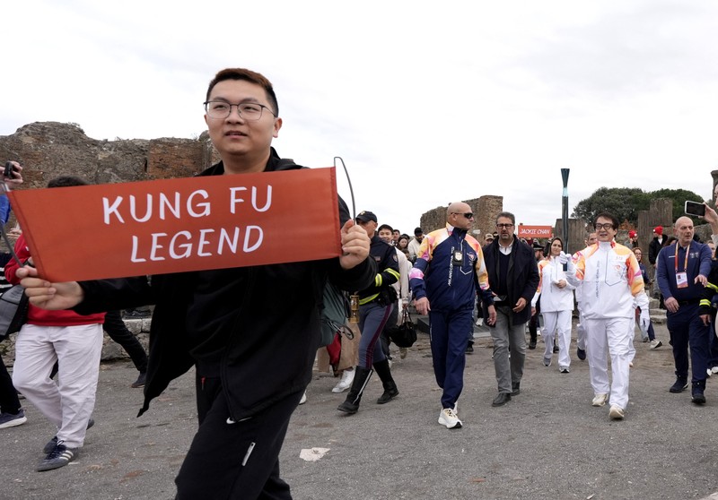 Olympics - 2026 Milano-Cortina Winter Olympics - 2026 Milano-Cortina Winter Olympics Torch Relay - Pompeii, Italy - December 22, 2025 Torchbearer actor Jackie Chan reacts during the torch relay REUTERS/Matteo Ciambelli