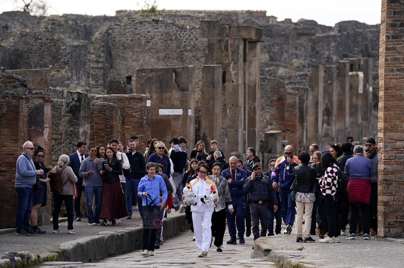 Olympics - 2026 Milano-Cortina Winter Olympics - 2026 Milano-Cortina Winter Olympics Torch Relay - Pompeii, Italy - December 22, 2025 Torchbearer actor Jackie Chan reacts during the torch relay REUTERS/Matteo Ciambelli