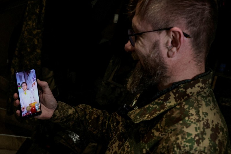 Service members of the 13th Operative Purpose Brigade 'Khartiia' of the National Guard of Ukraine eat during a Christmas Eve dinner at a position near a front line, amid Russia's attack on Ukraine, in Kharkiv region, Ukraine December 24, 2025. REUTERS/Sofiia Gatilova