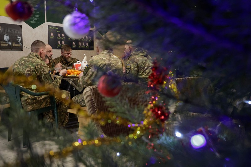 Service members of the 13th Operative Purpose Brigade 'Khartiia' of the National Guard of Ukraine eat during a Christmas Eve dinner at a position near a front line, amid Russia's attack on Ukraine, in Kharkiv region, Ukraine December 24, 2025. REUTERS/Sofiia Gatilova
