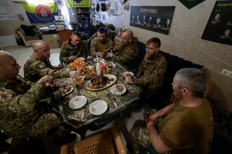 Service members of the 13th Operative Purpose Brigade 'Khartiia' of the National Guard of Ukraine eat during a Christmas Eve dinner at a position near a front line, amid Russia's attack on Ukraine, in Kharkiv region, Ukraine December 24, 2025. REUTERS/Sofiia Gatilova