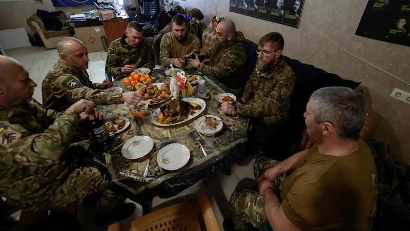 Service members of the 13th Operative Purpose Brigade 'Khartiia' of the National Guard of Ukraine eat during a Christmas Eve dinner at a position near a front line, amid Russia's attack on Ukraine, in Kharkiv region, Ukraine December 24, 2025. REUTERS/Sofiia Gatilova