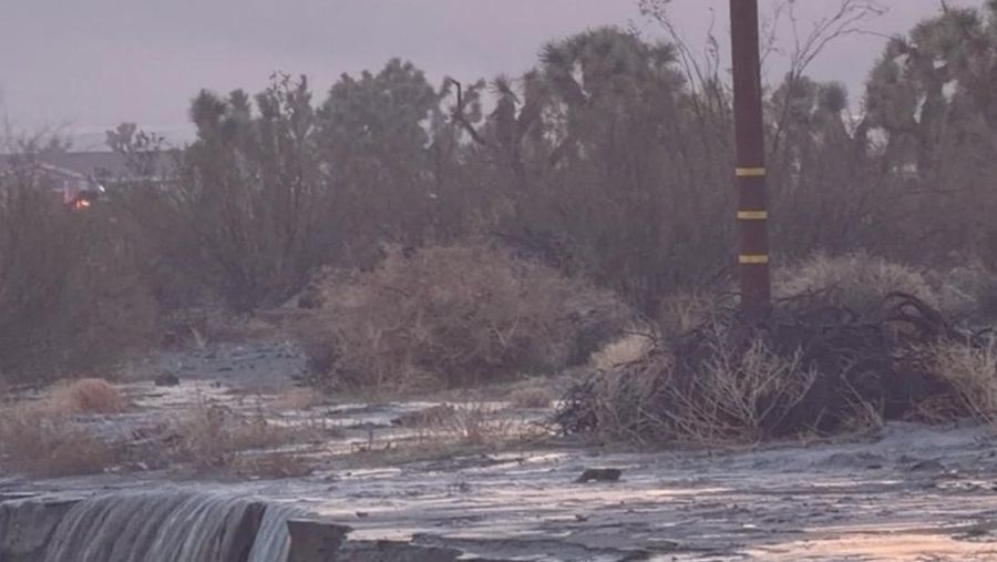 People sit on the roof of a building while they are stranded during floods partially submerging the surrounding area in the aftermath of torrential rains, in San Bernardino County, California, U.S. December 24, 2025 in this screengrab obtained from a social media video. Timothy and the Machine Music via Facebook/via REUTERS  THIS IMAGE HAS BEEN SUPPLIED BY A THIRD PARTY. MANDATORY CREDIT. NO RESALES. NO ARCHIVES.  Verification: Road layout, buildings and utility poles matched file and satellite images Date verified by original file metadata