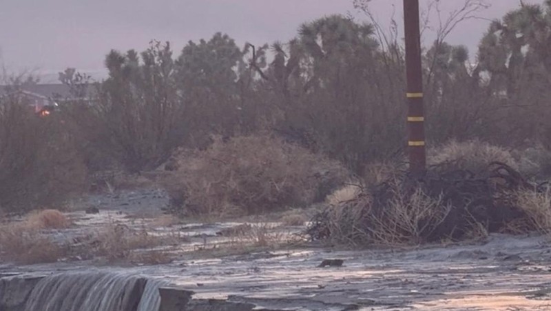 People sit on the roof of a building while they are stranded during floods partially submerging the surrounding area in the aftermath of torrential rains, in San Bernardino County, California, U.S. December 24, 2025 in this screengrab obtained from a social media video. Timothy and the Machine Music via Facebook/via REUTERS  THIS IMAGE HAS BEEN SUPPLIED BY A THIRD PARTY. MANDATORY CREDIT. NO RESALES. NO ARCHIVES.  Verification: Road layout, buildings and utility poles matched file and satellite images Date verified by original file metadata