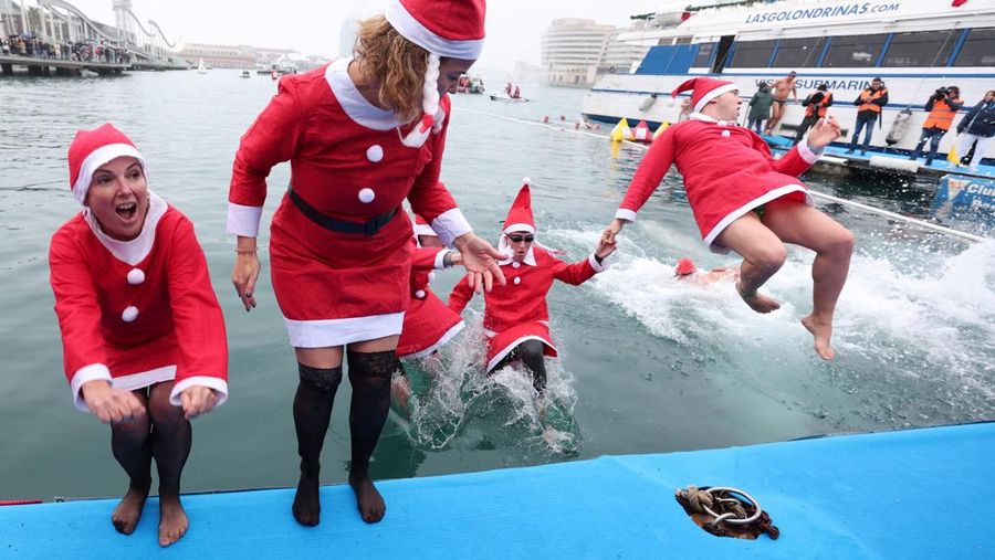 Orang-orang yang berpakaian seperti Santa Claus bersiap untuk melompat ke Laut Mediterania selama perlombaan renang Copa Nadal (Piala Natal) di Barcelona, ​​Spanyol. 25 Desember 2025. (REUTERS/Bruna Casas)