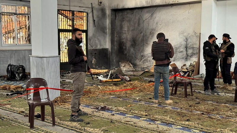 Pasukan keamanan Suriah berdiri di dalam masjid yang rusak setelah beberapa orang tewas dalam ledakan di sebuah masjid milik sekte minoritas Alawite, seperti yang dilaporkan oleh Kantor Berita Arab Suriah (SANA), di Homs, Suriah, 26 Desember 2025. (REUTERS/Ali Ahmed al-Najjar)