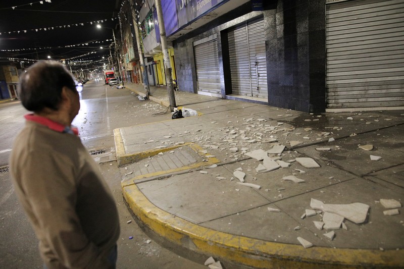 Warga berdiri di luar rumah mereka setelah gempa bumi di Chimbote, Peru, 27 Desember 2025. (REUTERS/Miguel Gutierrez)