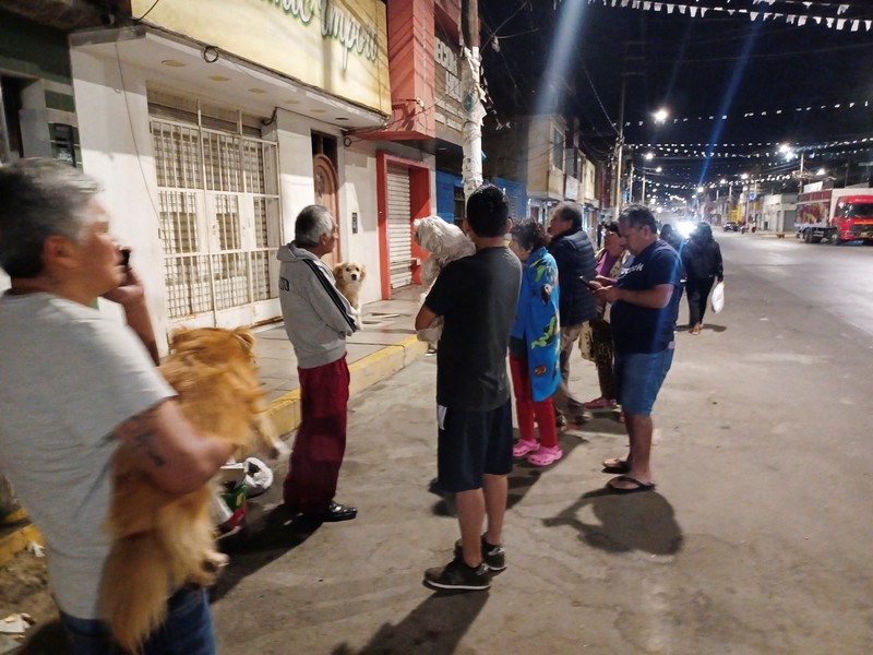Warga berdiri di luar rumah mereka setelah gempa bumi di Chimbote, Peru, 27 Desember 2025. (REUTERS/Miguel Gutierrez)