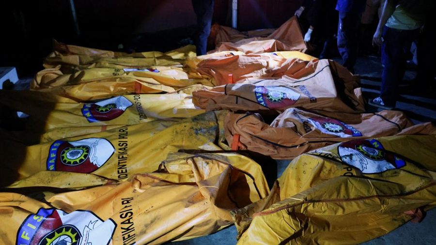 Local people rescue an elderly man during a fire at Werdha Damai retirement home in Manado, North Sulawesi Province, Indonesia, December 28, 2025. REUTERS/Yegar Sahaduta Mangiri