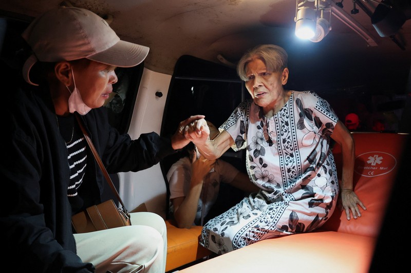 Local people rescue an elderly man during a fire at Werdha Damai retirement home in Manado, North Sulawesi Province, Indonesia, December 28, 2025. REUTERS/Yegar Sahaduta Mangiri