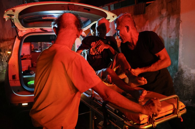 Local people rescue an elderly man during a fire at Werdha Damai retirement home in Manado, North Sulawesi Province, Indonesia, December 28, 2025. REUTERS/Yegar Sahaduta Mangiri