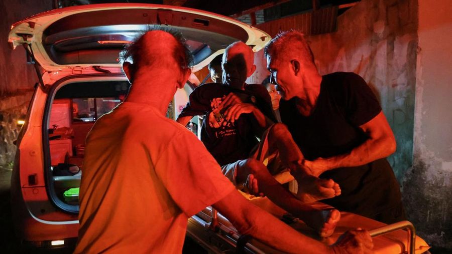 Local people rescue an elderly man during a fire at Werdha Damai retirement home in Manado, North Sulawesi Province, Indonesia, December 28, 2025. REUTERS/Yegar Sahaduta Mangiri
