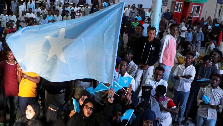 A woman holds a large Somali flag as Somalis attend a demonstration after Israel became the first country to formally recognise the self-declared Republic of Somaliland as an independent and sovereign state, a decision that could reshape regional dynamics and test Somalia's longstanding opposition to secession, in Hodan district of Mogadishu, Somalia, December 28, 2025. REUTERS/Feisal Omar