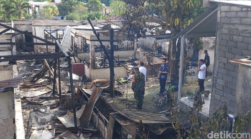 Local people rescue an elderly man during a fire at Werdha Damai retirement home in Manado, North Sulawesi Province, Indonesia, December 28, 2025. REUTERS/Yegar Sahaduta Mangiri