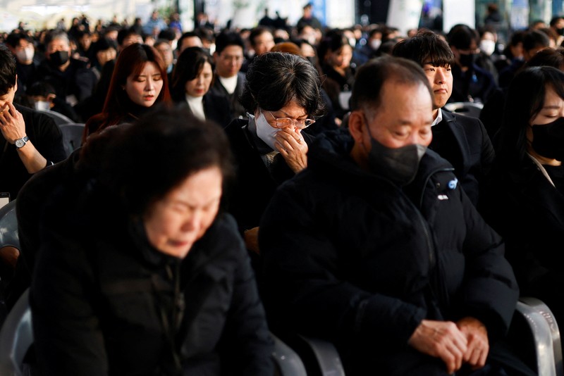 Para anggota keluarga yang berduka bereaksi selama upacara peringatan satu tahun kecelakaan pesawat Jeju Air yang menewaskan 179 orang, di Bandara Internasional Muan di Muan, Korea Selatan, 29 Desember 2025. (REUTERS/Kim Soo-hyeon)